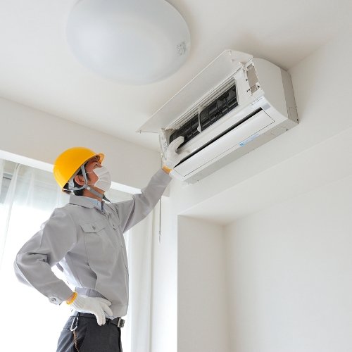 AC repair technician inspecting ductless system