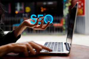 Woman hand holding glowing SEO letters