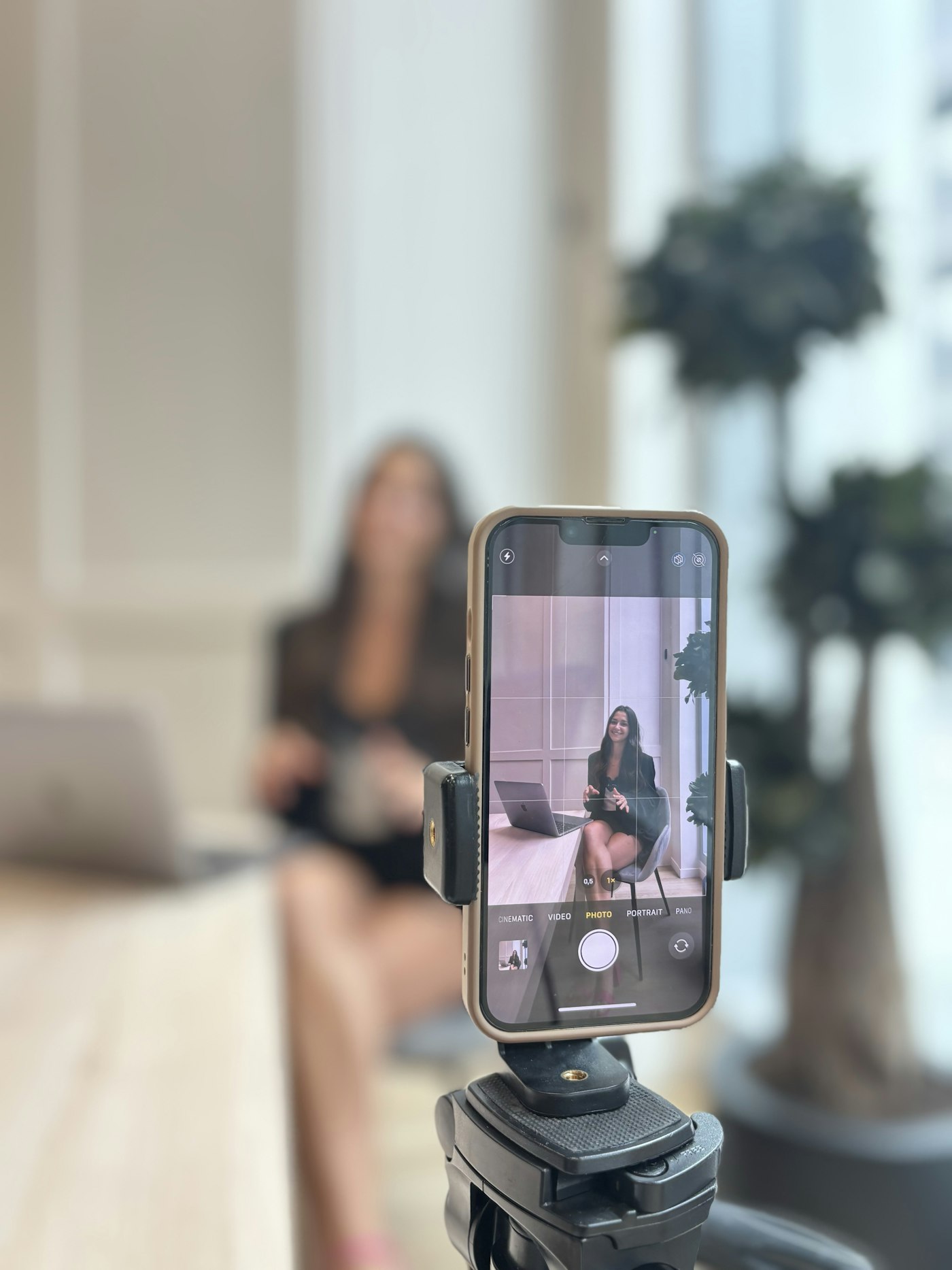 Business owner filming a social media video on her smartphone in the office