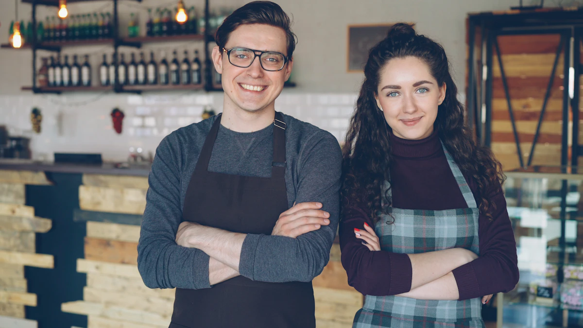 Two smiling cafe owners standing with arms crossed in front of their counter