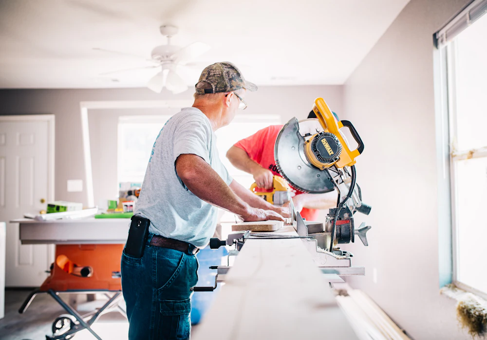 Carpenter cutting trim on a miter saw