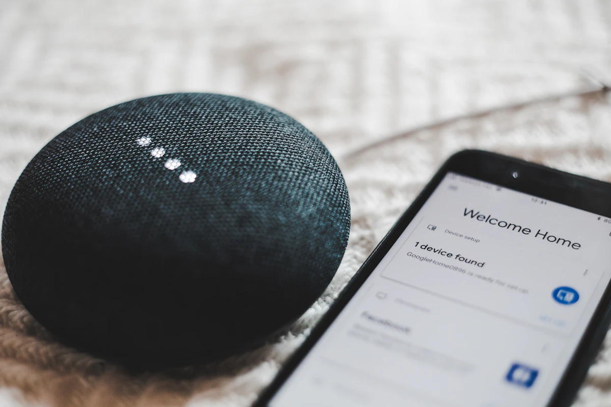 Smart speaker sitting next to a smartphone on a table