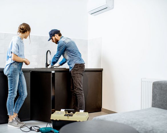 Plumber talking to customer while working